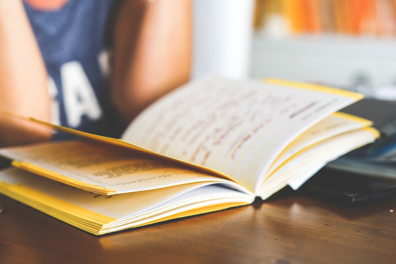 Studente alla scrivania con libro aperto davanti