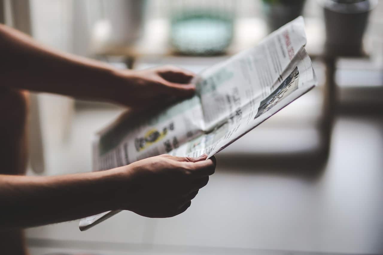 Mani che mantengono un giornale
