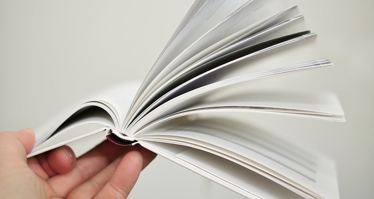 Mano che mantiene libro aperto