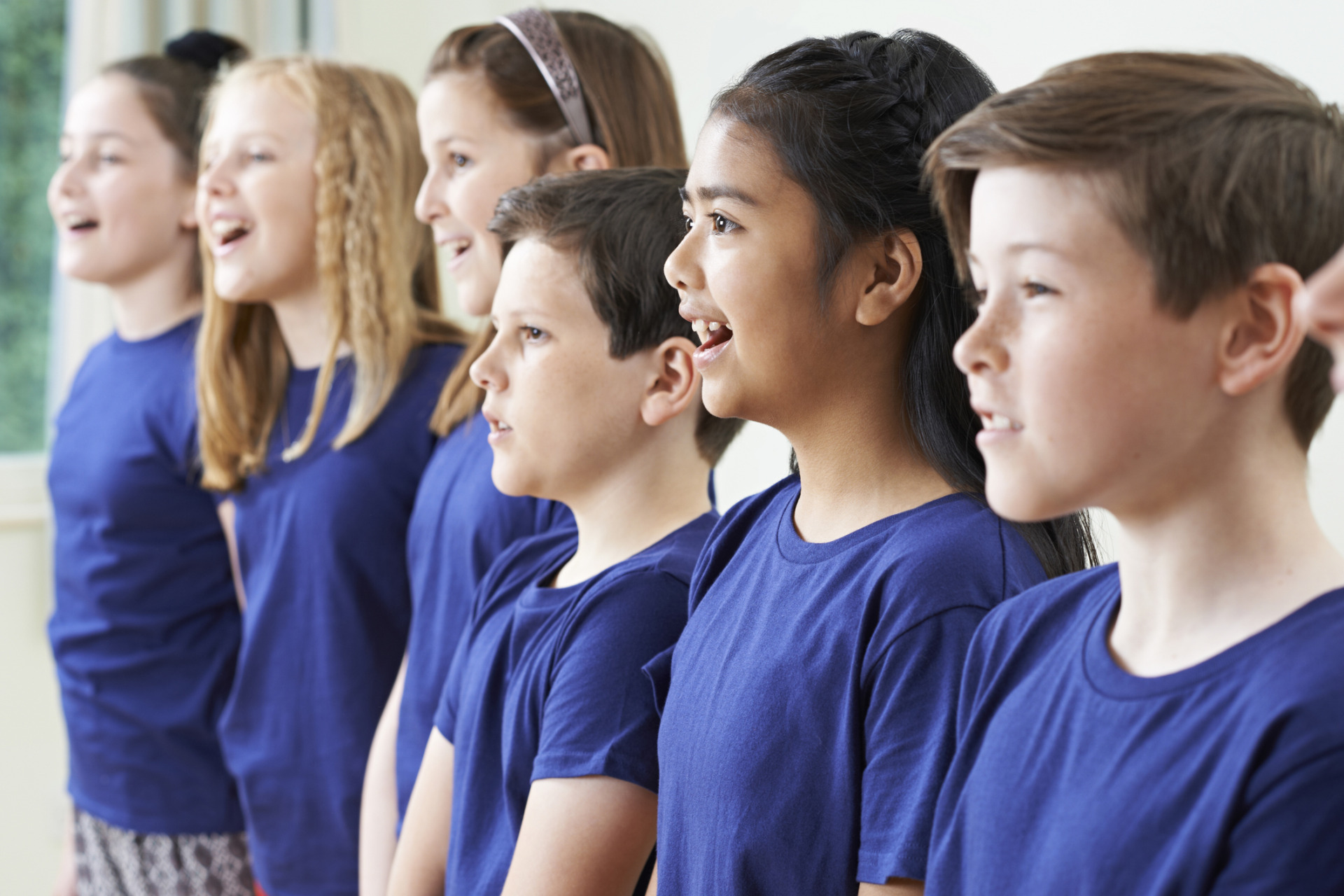 Group Of School Children Singing In Choir Together