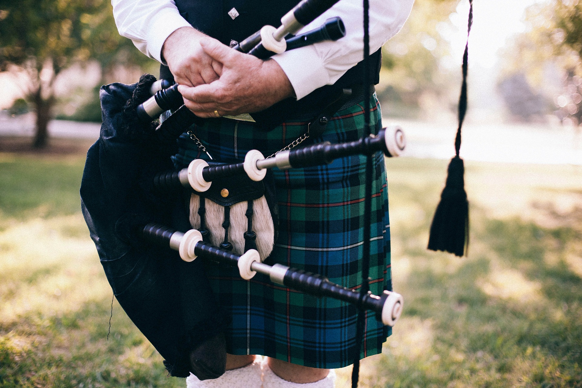 Uomo che indossa il kilt con in mano una cornamusa