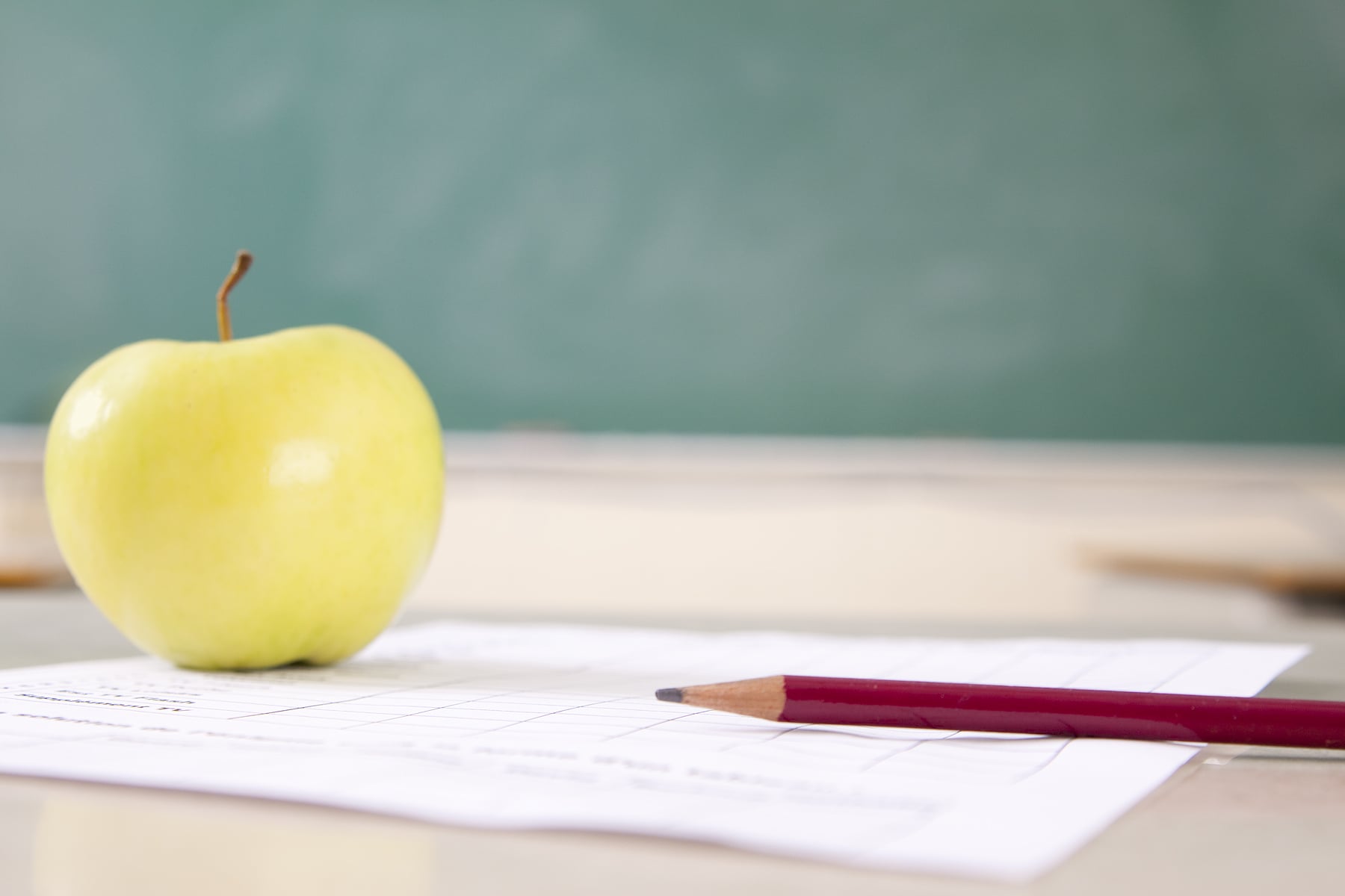 Mela gialla su banco di scuola
