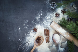 Tavolo con ingredienti per dolci natalizi e farina