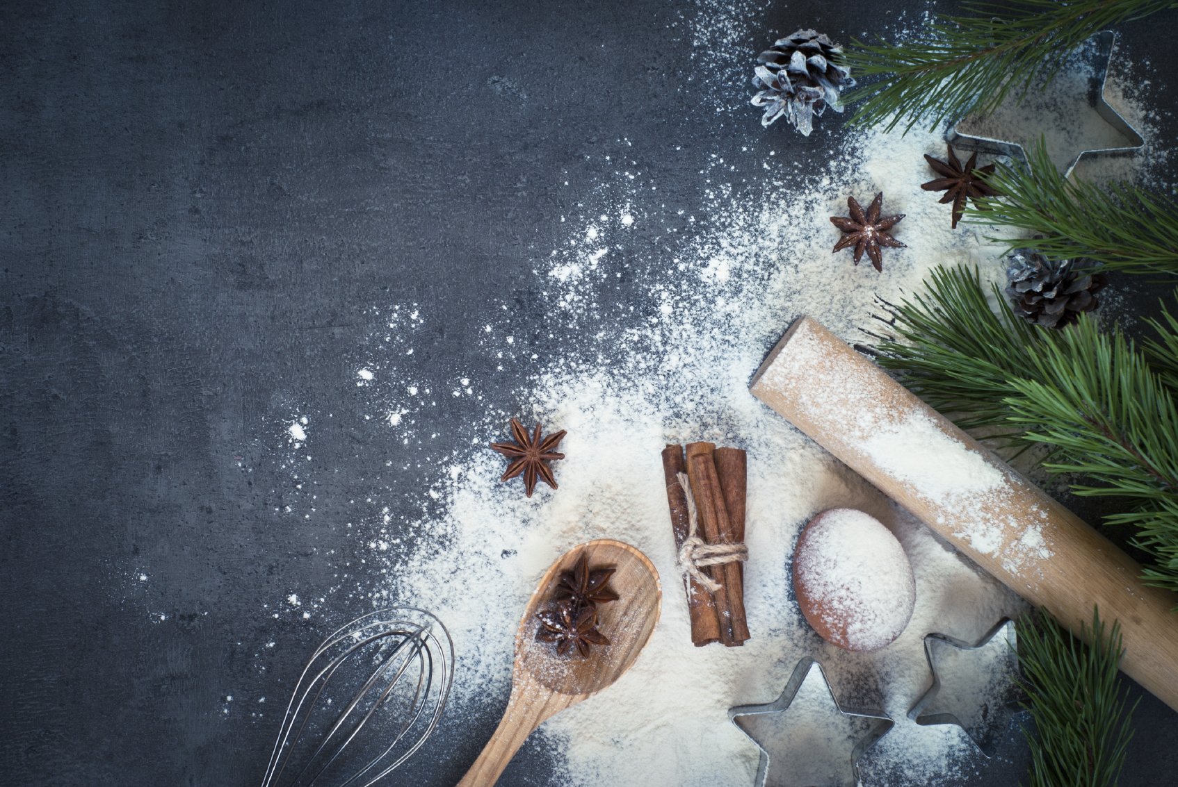Tavolo con ingredienti per dolci natalizi e farina