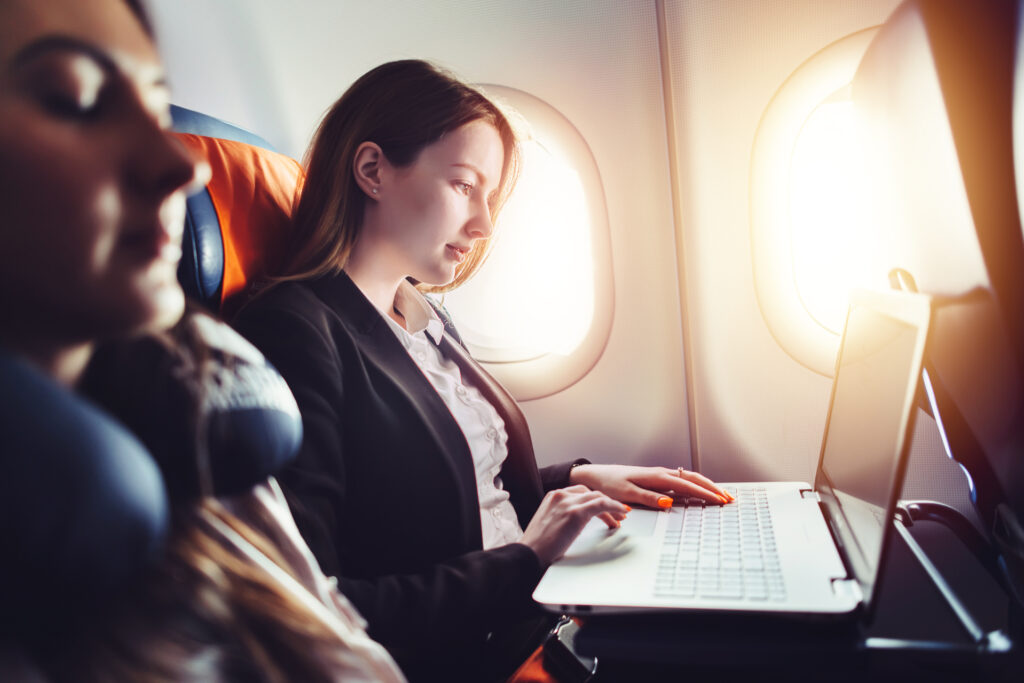 Donna in aereo con computer