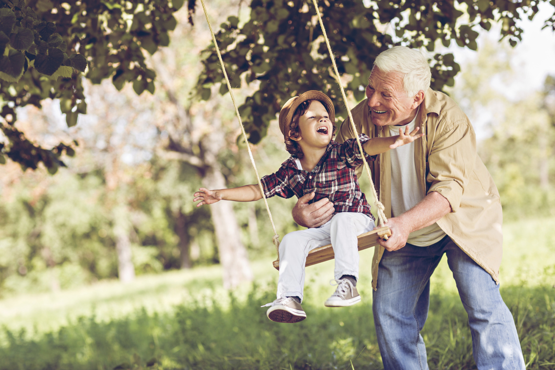 Nonno che spinge il nipote sull'altalena