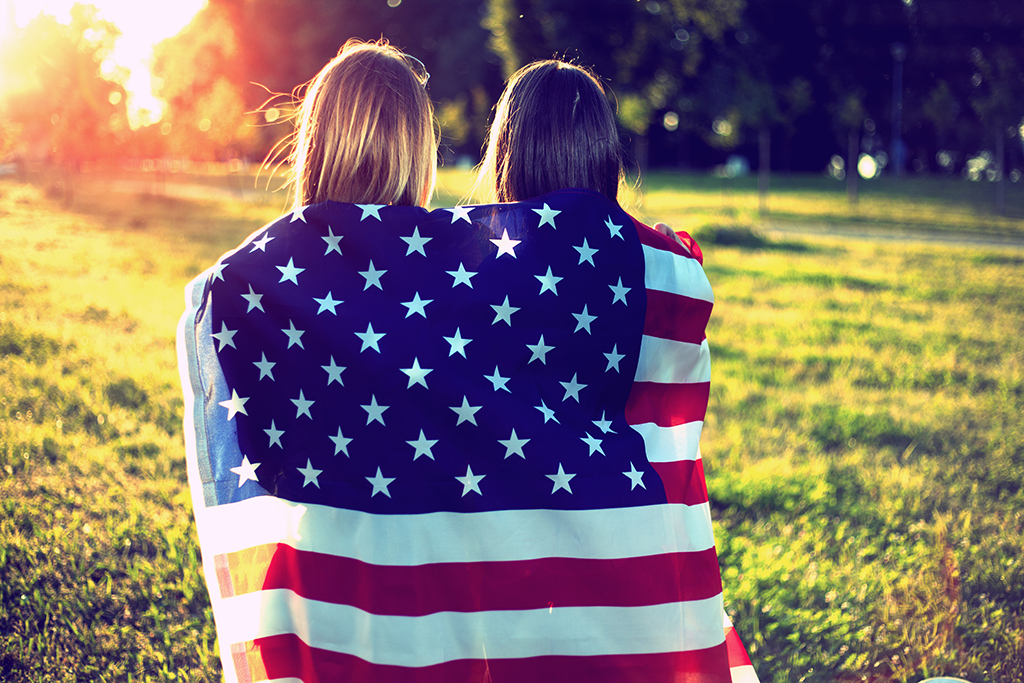 due ragazze avvolte nella bandiera americana