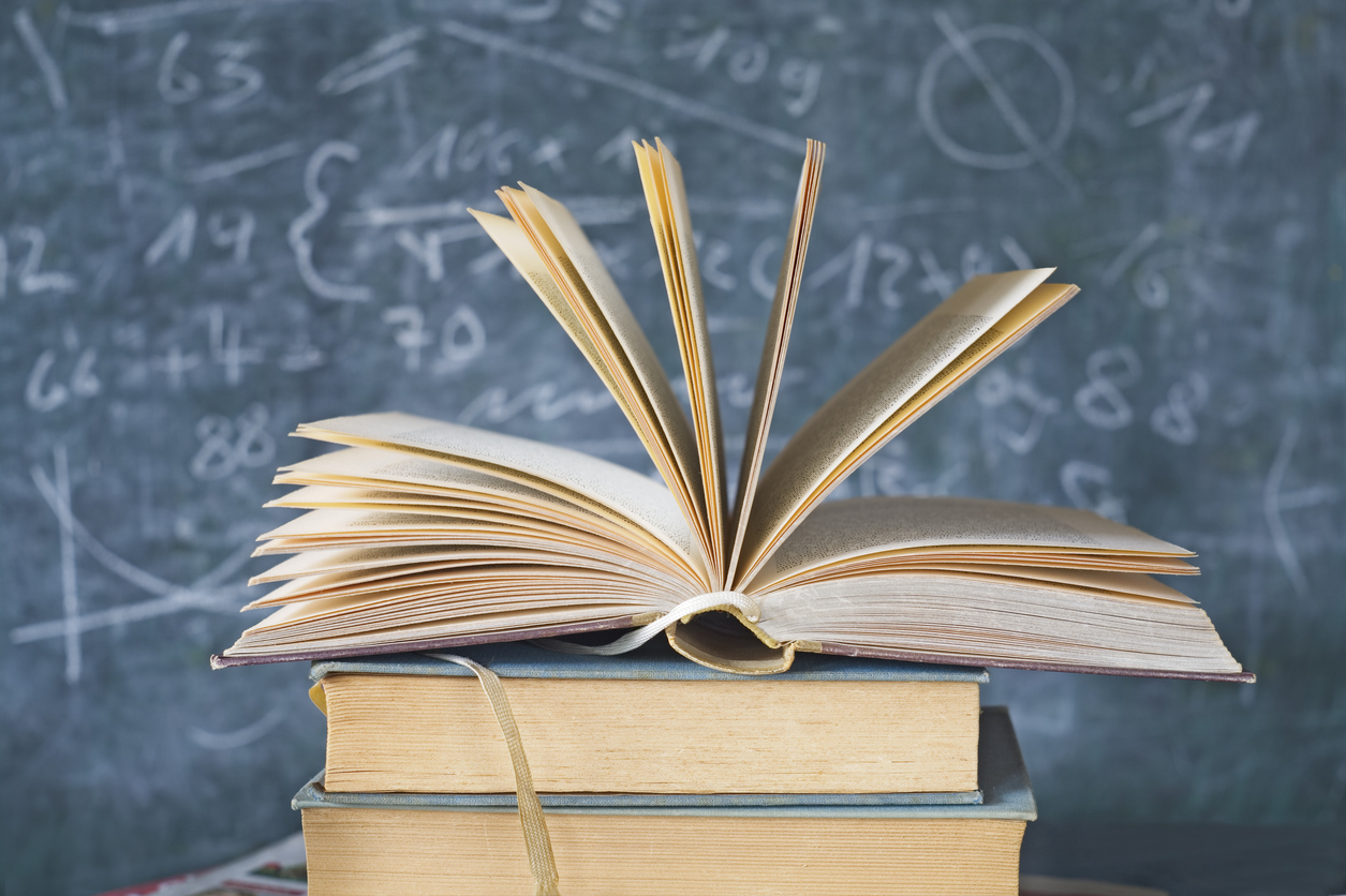 Libri sulla cattedra davanti alla lavagna
