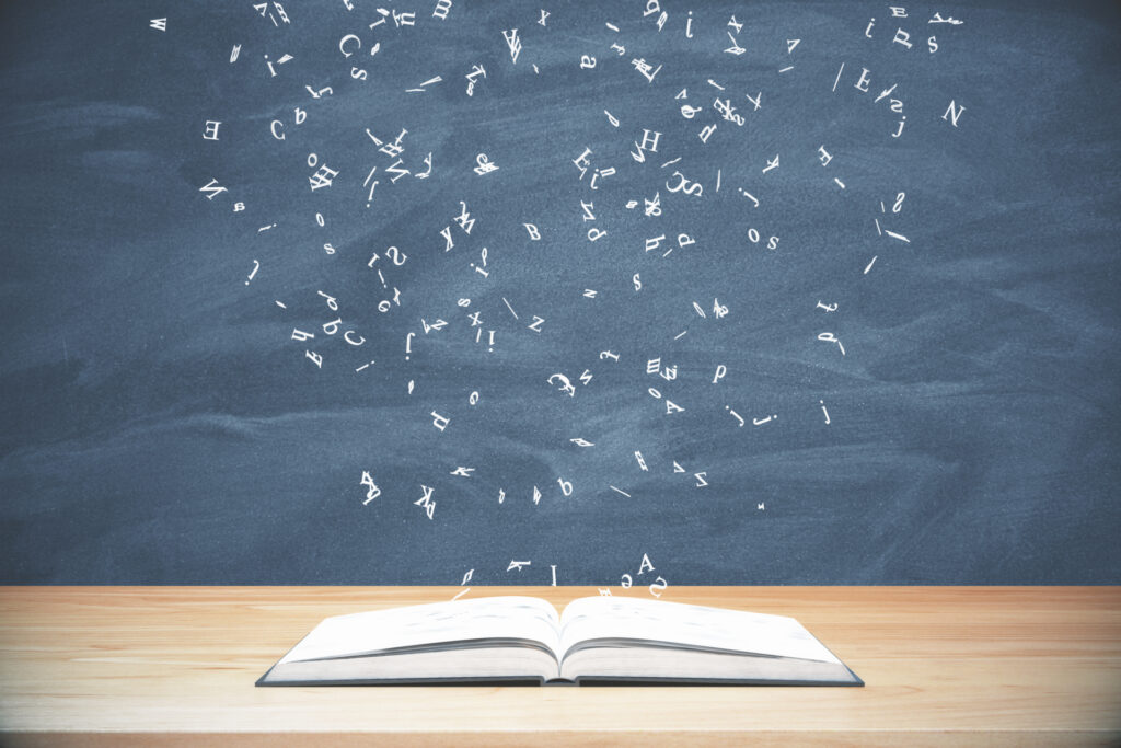 Libro aperto su cattedra con lavagna alle spalle