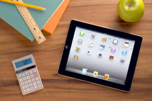 tablet con calcolatrice e una mela verde