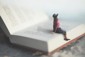 Ragazza seduta sulle pagine di un libro