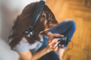 Ragazza seduta sul pavimento che ascolta la musica dallo smartphone