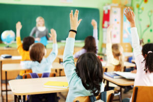 Studenti che alzano la mano in classe