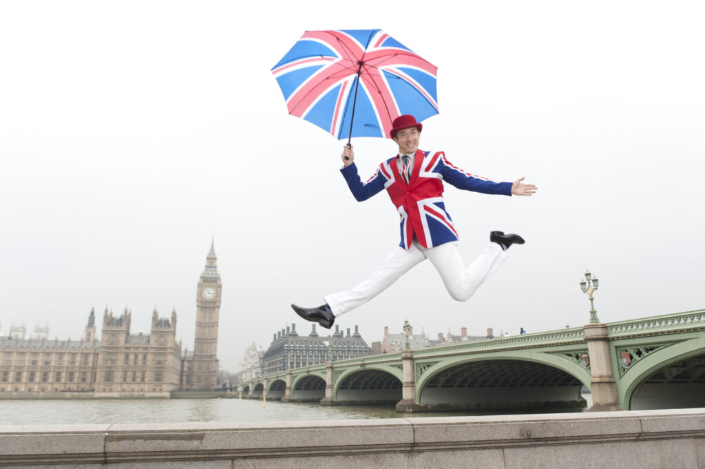 uomo vestito con la bandiera inglese che salta