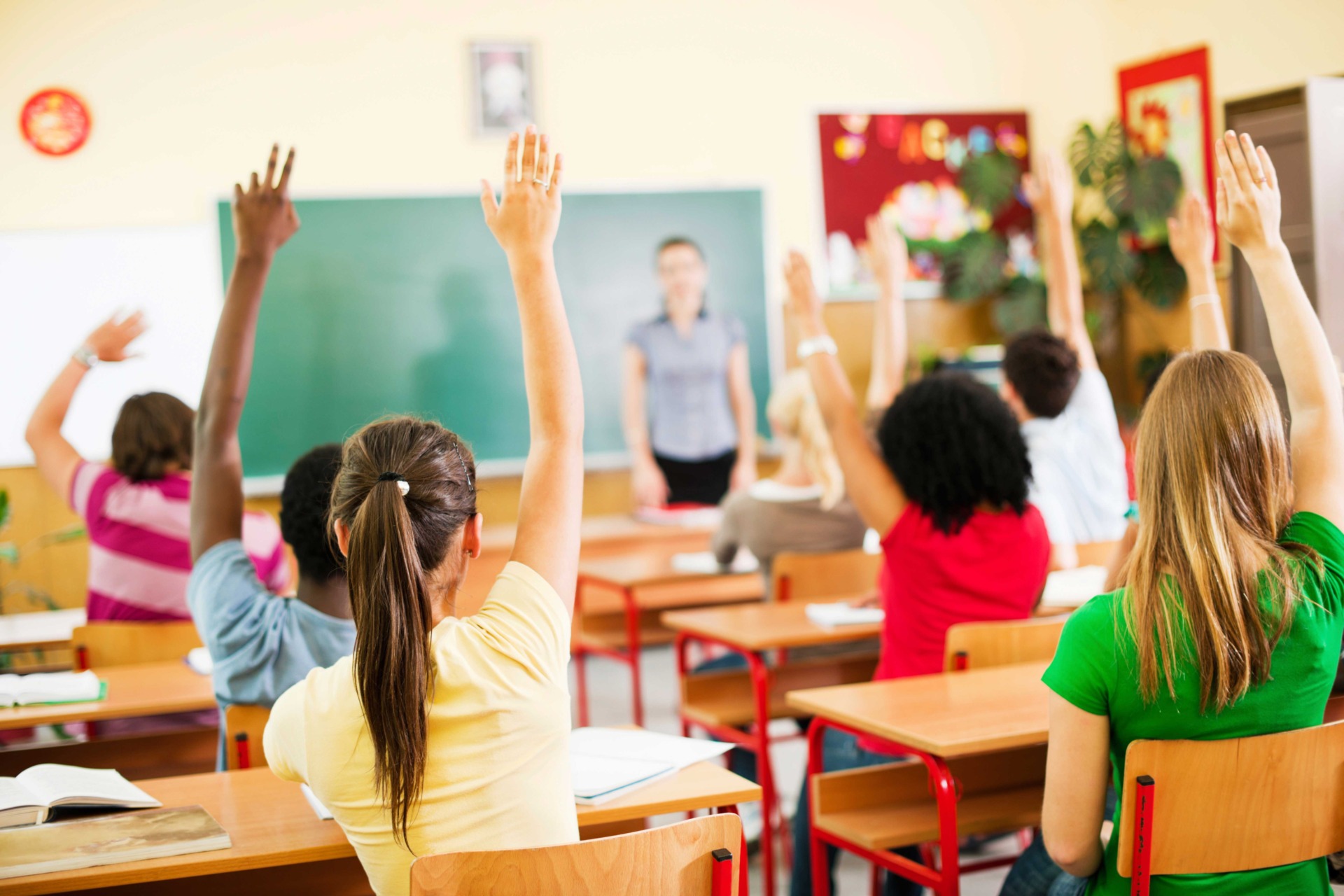 studenti in classe che alzano la mano per fare un domanda