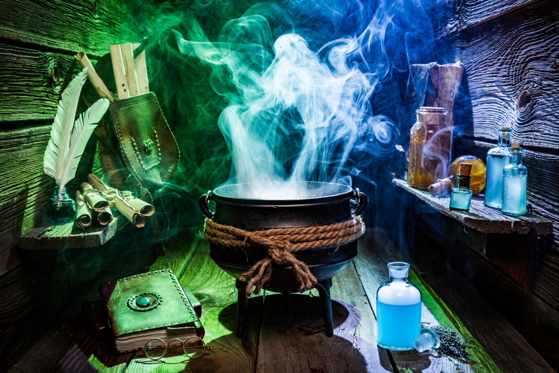 Vintage witcher cauldron with magic potions and books for Halloween