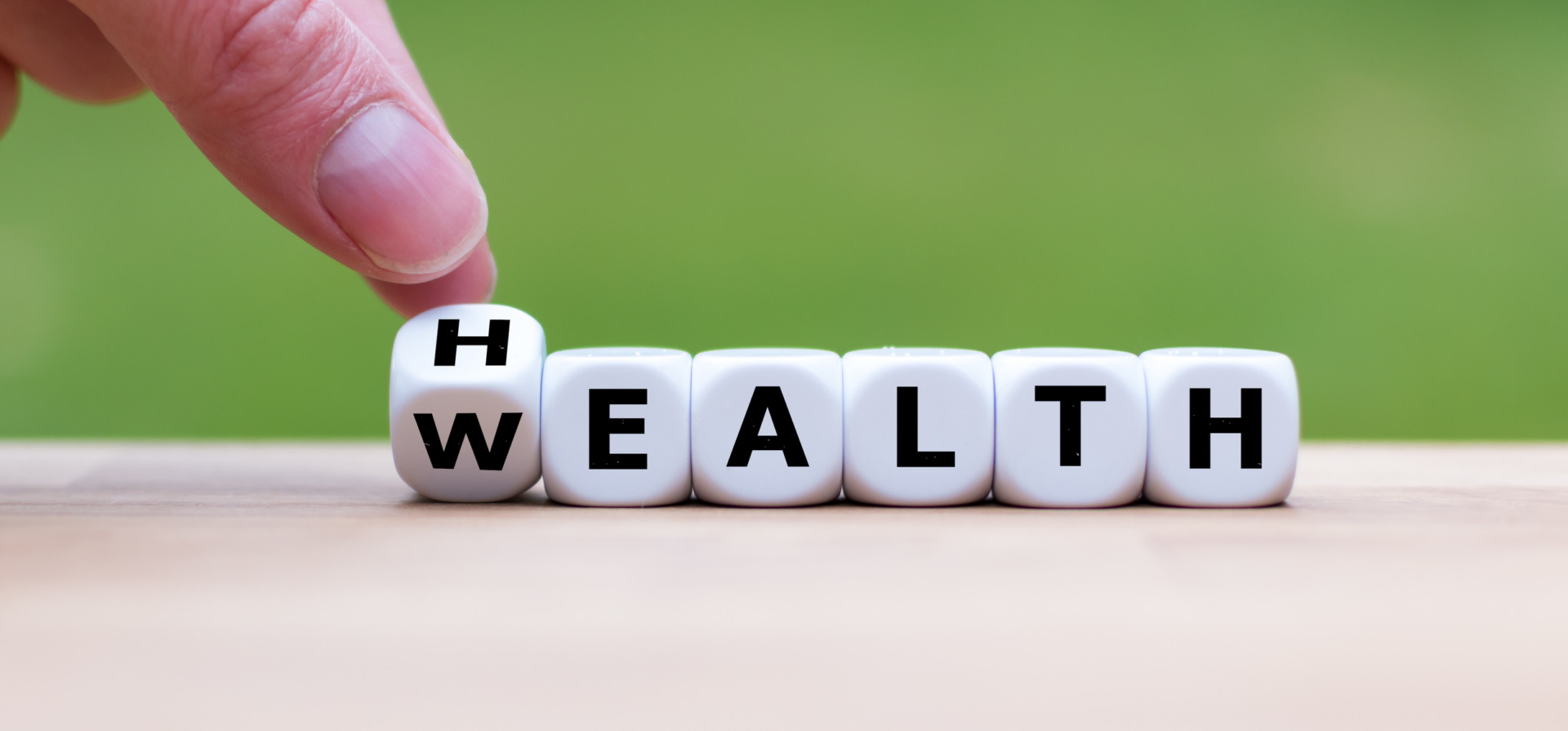 Ecco perché imparare le lingue fa bene alla tua salute Hand is turning a dice and changes the word "Health" to "Wealth"