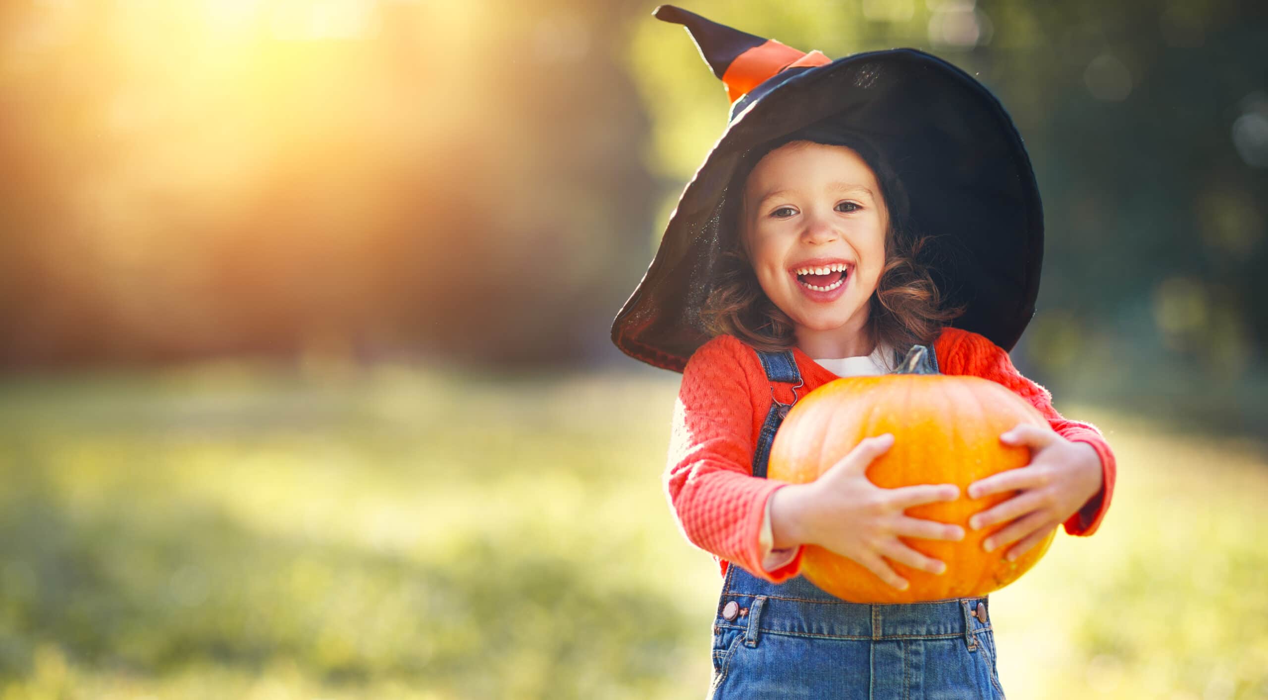 Halloween: la tradizione del "Pumpkin Patch" bambina vestita da strega con zucca