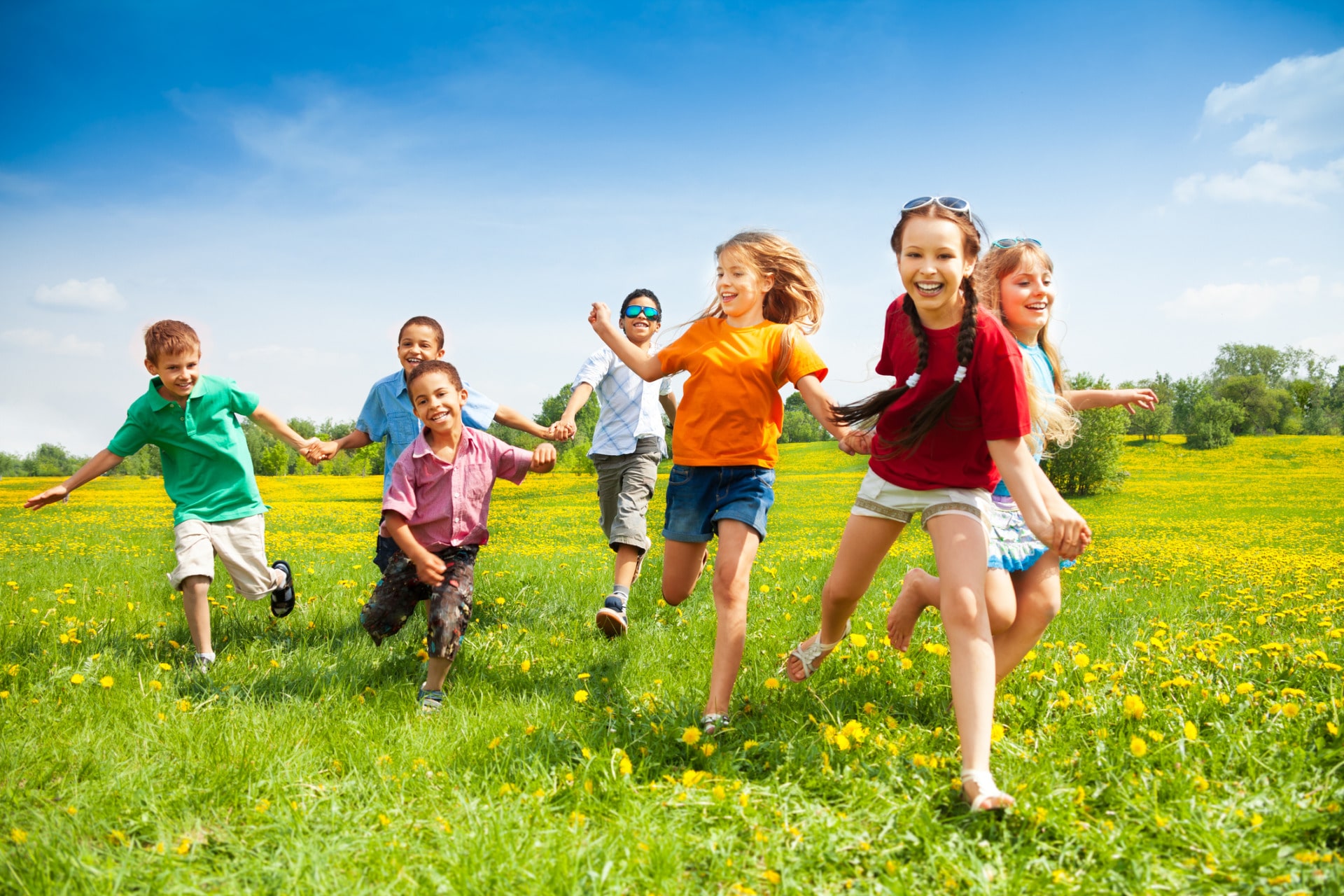 Qual è l'età giusta per la prima vacanza da soli? Bambini che corrono su un prato verde
