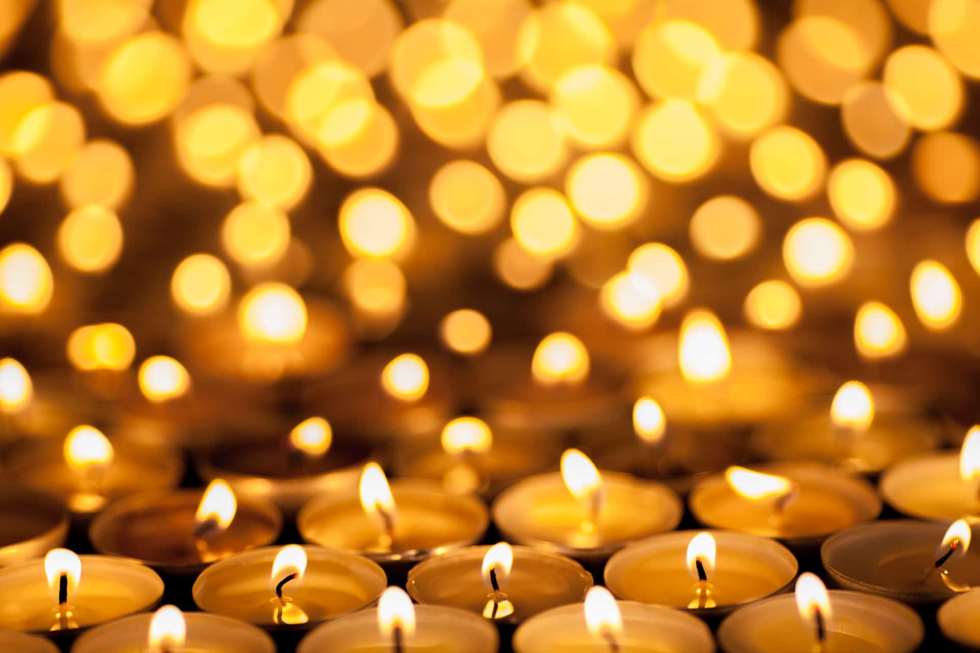 Remembrance day e i war poets Diwali Festival of Lights. Beautiful candlelight. Selective focus on foreground of many burning tealight candles.