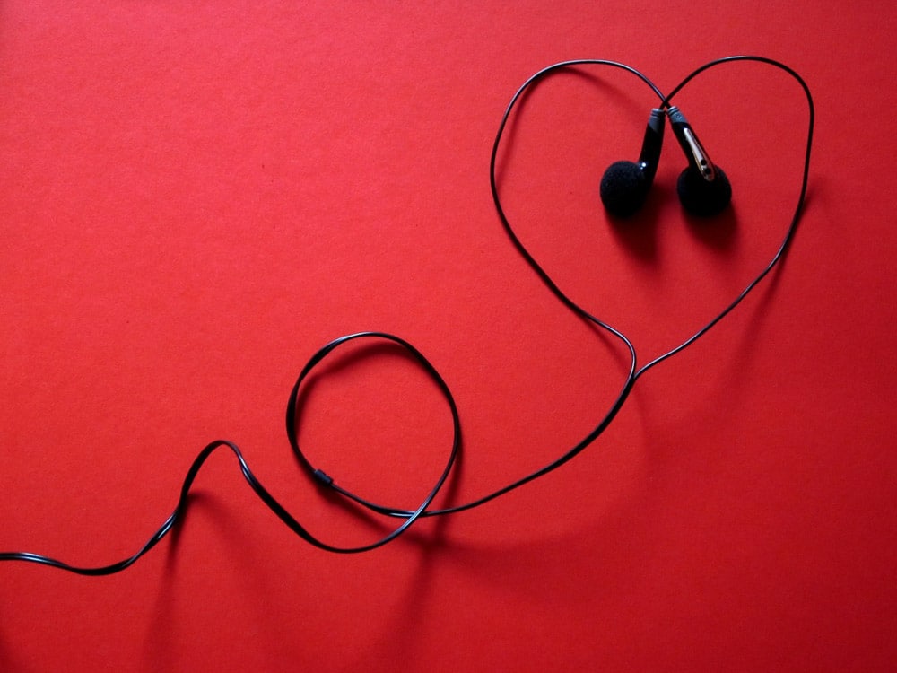 Come imparare l’inglese con le canzoni Cuffie che formano un cuore su uno sfondo rosso