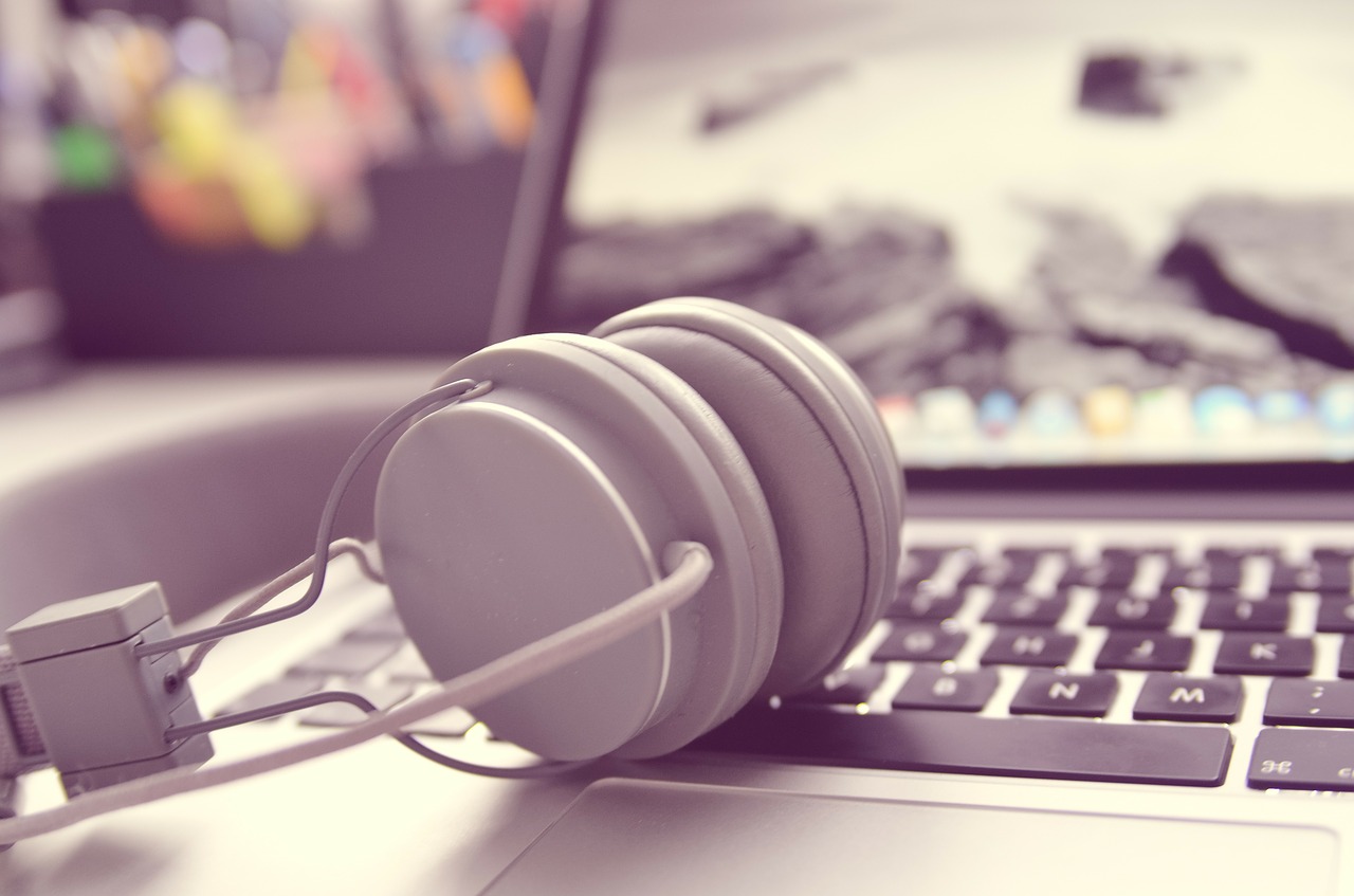5 modi per praticare l’inglese quotidianamente cuffie appoggiate su un pc portatile