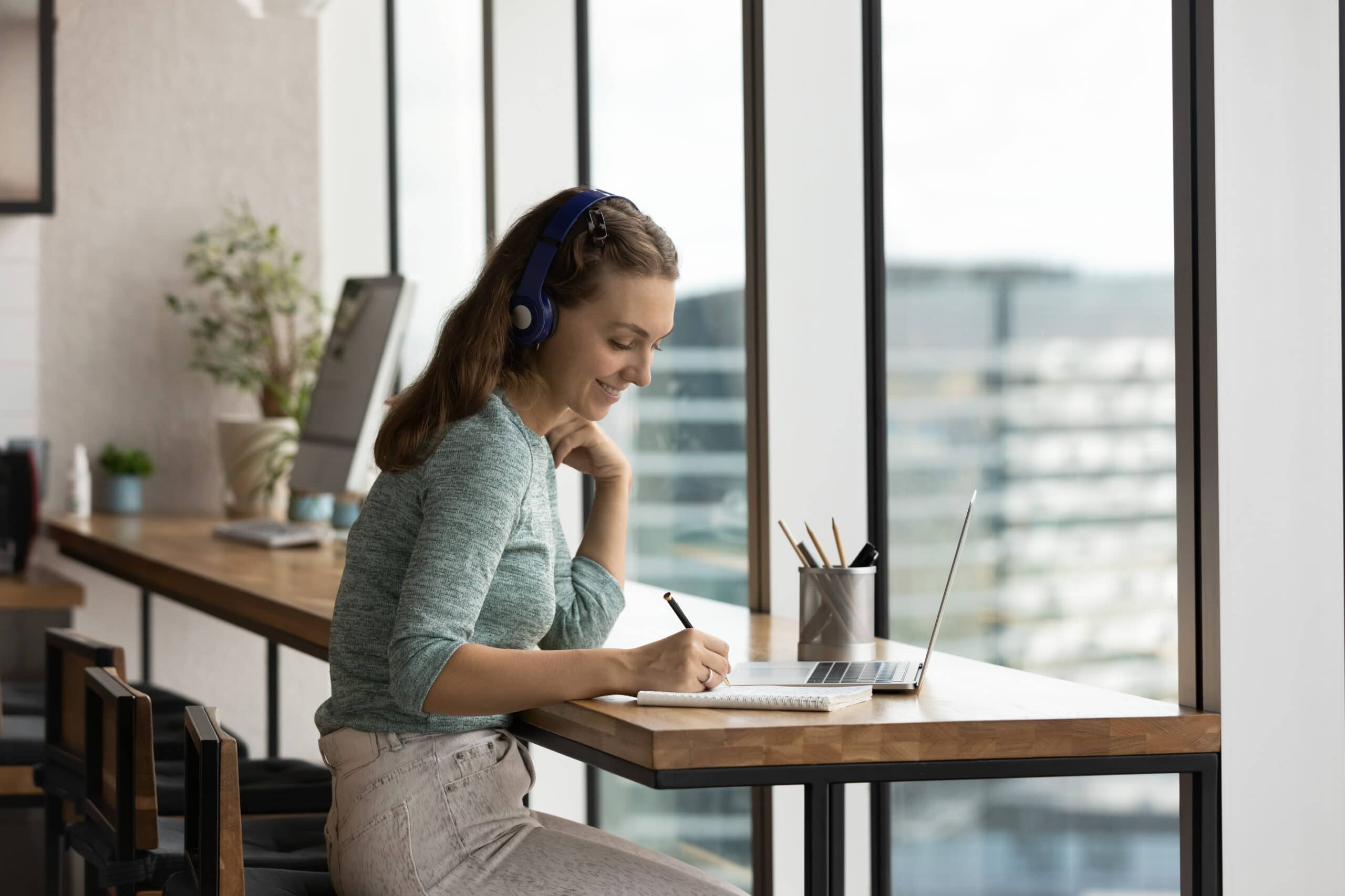 Imparare le lingue con i podcast: spunti e vantaggi! ragazza con cuffie che scrive