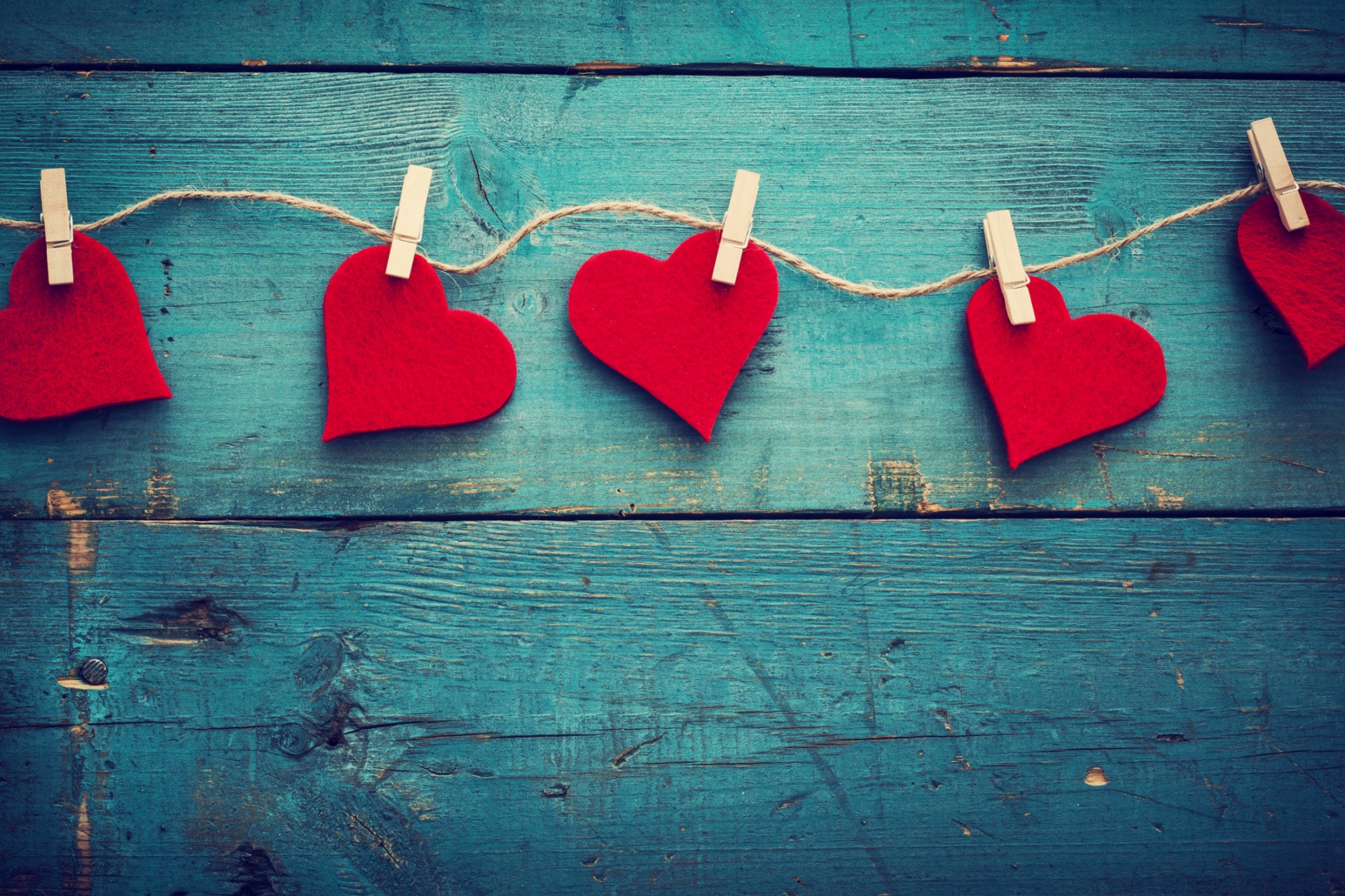 Valentine’s Day with Shakespeare . Love in Shakespeare or Shakespeare in love? Cuoricini rossi su un filo con sfondo in legno